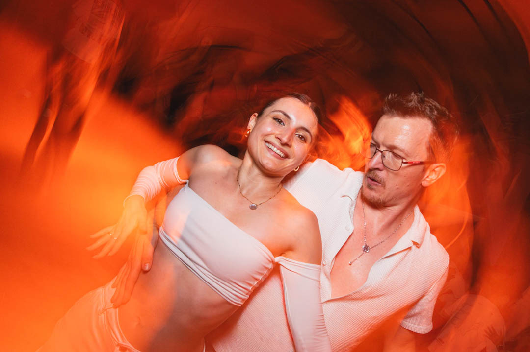 A dancing couple captured in luminous motion on the floor